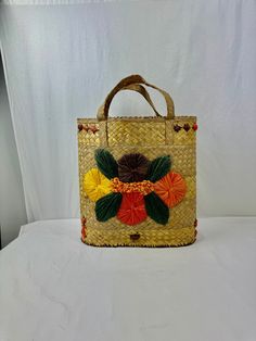 "Retro-style straw beach bag is made of woven straw strands and raffia stitched flowers. The bag is 15\" tall with a 6\" handle and is 14\" wide.  Base is 8.5\" wide.   There is some staining and holes inside the lining of the bag. Please see photos. And handles are a bit frayed. Otherwise, in very good vintage condition.  Would be a great beach bag, or could be displayed as art or used as storage for towels, blankets, etc. This shop uses recycled shipping materials in order to limit shipping costs and reduce waste." Storage For Towels, Raffia Flowers, Flowers Bucket, Stitched Flowers, Straw Beach Bag, Flower Bucket, Woven Bag, Retro Stil, Style Retro