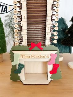 a wooden model of a window with the words the pinders on it and trees in the background