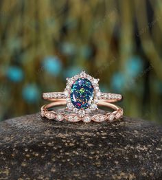 a blue and white diamond ring sitting on top of a rock