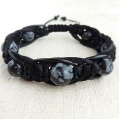 The protection bracelet made of beads Snowflake obsidian (12mm, 10mm) , braided with three cords of different texture (satin cord, waxed cord and leather cord). Obsidian is lustrous volcanic glass; molten lava that cooled so quickly it had no time to crystallize. Obsidian has no boundaries or limitations, as a result works extremely fast and with great power. Obsidian is a strongly protective stone, forming a shield against negativity, provides a grounding cord from the base chakra to the center of the earth. Obsidian absorbs negative energies from the environment, blocks psychic attacks and removes negative spiritual influences. Obsidian brings clarity to the mind, confidence and ease while anchoring the spirit into the body and stimulating growth on all levels. Snowflake Obsidian is a st Men Leather Bracelet, Base Chakra, Molten Lava, Obsidian Bracelet, Beaded Snowflakes, Bracelet Men, Snowflake Obsidian, Protection Bracelet, Mens Leather Bracelet