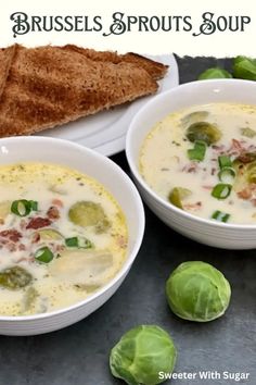 two white bowls filled with soup next to bread and brussels sprouts on a table