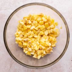 chopped potatoes in a glass bowl on top of a white countertop, ready to be used as an appetizer