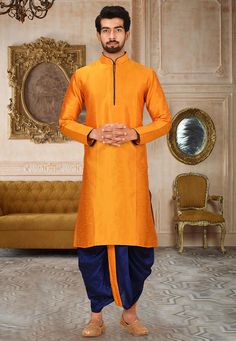 Art Dupion Silk Kurta in Orange This Readymade attire is Enhanced with Buttons Available with an Art Dupion Silk Dhoti Pant in Navy Blue Do note: Footwear shown in the image is for presentation purposes only. Half to one inch may vary in measurement. (Slight variation in actual color vs. image is possible) Traditional Handloom Sherwani With Drape, Art Silk Kurta With Traditional Drape For Puja, Orange Sets With Zari Weaving In Traditional Drape, Traditional Orange Sets With Traditional Drape, Traditional Drape Handloom Sherwani For Festivals, Orange Sherwani With Pallu For Festivals, Traditional Handloom Sherwani For Festivals, Semi-stitched Orange Sets For Puja, Orange Art Silk Kurta For Festivals