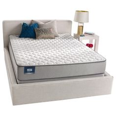 an image of a mattress on a bed frame with pillows and throw pillows in it