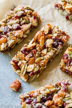 homemade granola bars with cranberries and almonds on parchment paper, ready to be eaten