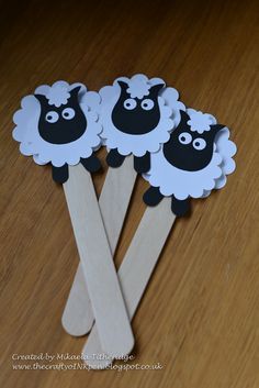 three sheep on sticks are sitting on the floor