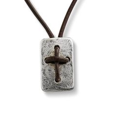 a cross on a leather cord with a metal pendant hanging from it's side