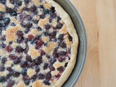 a pie with blueberries and crumbled toppings in a pan on a wooden table