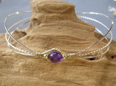 A delicate wirewrapped design fashioned in sterling silver and featuring a 6mm smooth round amethyst bead. Purple amethyst is the birthstone for February. This popular design is a lovely, feminine bracelet, perfect for a February birthday girl, whether she's young or old! Or a fabulous treat for yourself, especially if you just love purple! The hook and eye clasp is easy to get on and off yourself. Choose your size from the variations listed. Adjustable Amethyst Beaded Bracelets With Birthstone, Purple Wire Wrapped Bracelets As Gift, Amethyst Bangle For Gift, Handmade Amethyst Bangle As A Gift, Handmade Amethyst Bangle For Gift, Handmade Purple Wrap Bracelet As Gift, Hand Wrapped Purple Bracelets As Gift, Hand Wrapped Bangle Wrap Bracelet As Gift, Stackable Round Wrap Bracelet As Gift