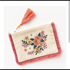 an embroidered purse with tassels and flowers on it