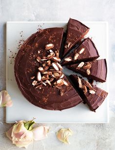 a chocolate cake with almonds on top and one slice cut out from the cake