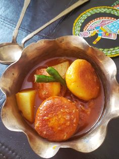 a metal bowl filled with food on top of a table