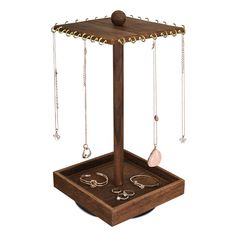 a wooden jewelry stand with several necklaces and rings hanging from it's sides