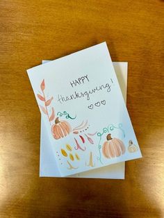 two greeting cards on top of a wooden table