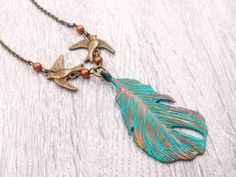 "This is the whimsical woodland inspired verdigris patina feather and bird necklace. The hand painted turquoise feather is tipped in rustic gold color on the top. A lovely pair of swallow birds with matching copper glass pearl are linked together to complete the design. It is suspended in a brass chain along with lobster claw clasp closure. The hand painted finish is slightly various of each feather. It is a wonderful idea for gift giving or as a little treat for yourself. Your necklace will pre Turquoise Feather Jewelry As A Gift, Turquoise Feather Jewelry As Gift, Adjustable Feather Necklace As Gift, Gold Laurel Wreath, Swallow Birds, Whimsical Woodland, Woodland Jewelry, Swallow Bird, Feather Necklace