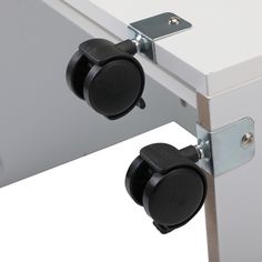 two black knobs are attached to the side of a white cabinet with metal latches