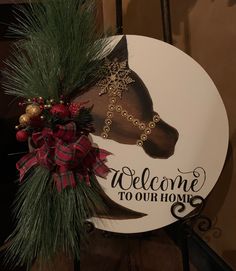 a welcome sign with a horse head on it's side and a red bow