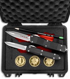 a swiss army knife and two gold coins in a case with the contents opened to show them