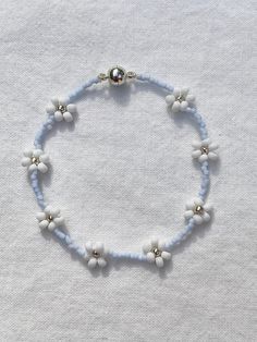 "Handmade, 6.5 inch, delicate light blue beaded bracelet. Woven into a Daisy Chain pattern and perfect for all ages. Beautiful for layering and on its own as well! Makes a great gift and is perfect for friendship bracelets! Every bracelet is finished with a magnetic clasp for easy wearing. Primary color refers to the color in the center of the Daisy. The \"Clear\" primary color can be glow-in-the-dark if requested. If selecting a non-metallic primary color, please specify in the personalization Dark Blue Beaded Bracelet, Daisy Chain Pattern, Trendy Summer Jewelry, Light Blue Jewelry, Light Blue Bracelet, Daisy Chain Bracelet, Blue Bracelets, Tiny Bead Bracelet, Gelang Manik-manik