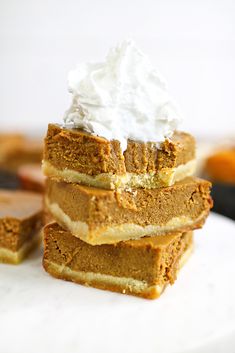 three slices of pumpkin pie stacked on top of each other with whipped cream on top