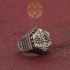 This handcrafted men's silver ring bears the profound Hadith 'المرء مع من أحب' (One is with whom he loves) on a silver plaque, a reminder of love's bond in Islamic tradition. The ring's hexagonal form is adorned with an intricate Abjad numerals motif, symbolizing the mystique of Arabic numerals. This piece is a fusion of spiritual meaning and artistic craftsmanship, making it a unique addition to any collection or a heartfelt gift. *General Description* -All Kuyumcuzade products are made of 925 Desired Features, Ring Bear, Islamic Jewelry, Spiritual Meaning, Mens Silver Rings, Heartfelt Gifts, Signet Ring, Rings Statement, Favorite Jewelry