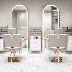 two white chairs sitting in front of mirrors on top of a floor next to each other