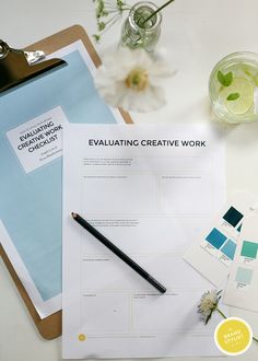 a clipboard with some writing on it next to a pen and paper that says evaluating creative work