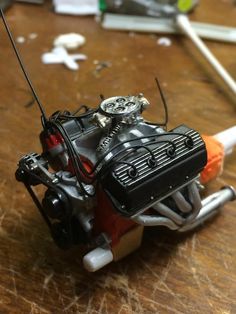 a close up of a toy motorcycle on a wooden table with tools in the background