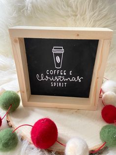 coffee and christmas spirit written on a chalkboard surrounded by pom - poms