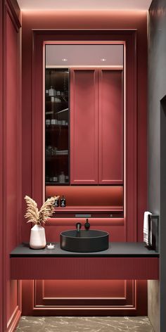 a bathroom with red walls and a black sink in front of a mirror on the wall