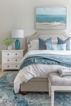 a bedroom with blue and white decor on the bed, dressers and nightstands