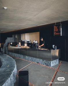 a man standing behind a counter in a restaurant