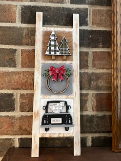 an old ladder is decorated with christmas decorations and other things to hang on the wall