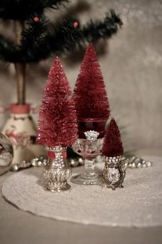 three small christmas trees sitting on top of a table