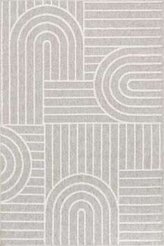 a white rug with grey lines and circles on the ground, in front of a gray background