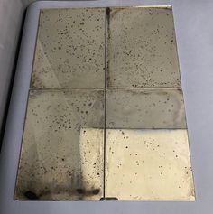 a square metal plate with some dirt on it