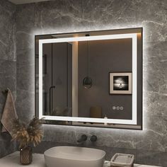 a bathroom with a sink, mirror and lights on the wall above it's counter