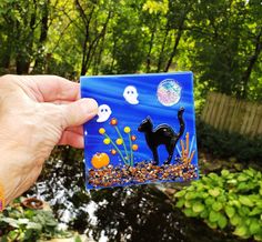 a hand holding up a card with a black cat on it