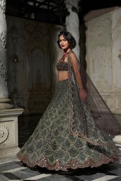 This lehenga set features stone work in tones of emerald green. The blouse has stone work in nude tones with crystal tassels at the waist. The matching dupatta has scalloped border.From Seema Gujral's Inara collection. DELIVERY TIMEPlease allow 8-12 weeks for your outfit to arrive. FABRIC DETAILSNet Professional cleaning only. Emerald Green Bridal Lehenga, Dark Green Bridal Lehenga, Dark Lehenga, Sangeet Outfit Bridal, Green Bridal Lehenga, Dark Green Lehenga, Reception Outfits, Bridal Trousseau, Gold Lehenga