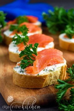 several pieces of bread topped with salmon and parsley