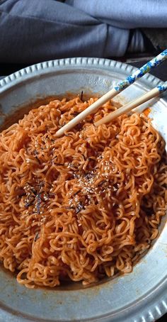 chopsticks sticking out of a bowl of noodles