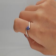 Gracefully coiling around the finger, this tanzanite triangle bypass ring exudes super-natural beauty. A tanzanite gemstone ring reveals tonal depth ranging from lilac-blue to deep-blue violet with exceptional contrast in sterling silver. | Tanzanite Triangle Bypass Ring | Sterling Silver | White | Size 7 | Helzberg Diamonds Triangle Tanzanite Ring, Modern Tanzanite Rings, Modern Tanzanite Jewelry For Promise Ring, Modern Tanzanite Sapphire Promise Ring, Bypass Rings, Blue Engagement Ring, Lilac Blue, Country Rings, Triangle Ring