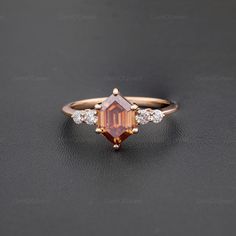 an orange and white diamond ring on a black surface