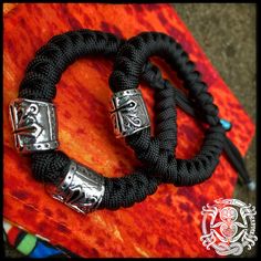 Standard Templar helmet bead on a black snakeknot bracelet with slide-to-close closure. The Templar Brothers version has two Templar beads on the same setup. Black Viking Style Outdoor Jewelry, Black Viking Style Jewelry For Outdoor, Black Viking Jewelry For Outdoor, Adjustable Black Viking Bracelet, Handmade Viking Style Black Bracelet, Handmade Black Braided Bracelets For Outdoor, Adjustable Black Paracord Jewelry, Templar Helmet, A Black