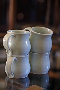 two white mugs sitting on top of a table