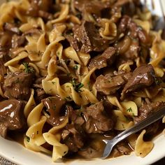 a white plate topped with beef and noodles