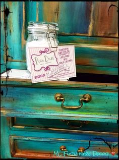 a mason jar with a note attached to it sitting on top of a chest of drawers