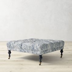 an upholstered footstool in marbled fabric