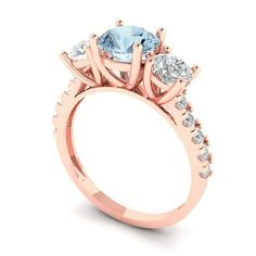 a rose gold engagement ring with an aqua blue topazte and two white diamonds