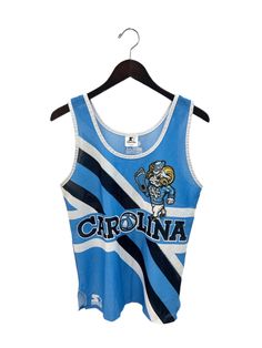 "early 90s UNC tank. by starter. carolina blue, navy, & white. sublimated graphics. side slits. 22.5\" long.  19\" across. in good, used condition. made in USA. legit. legitvintage.etsy.com legitvintage on instagram" Collegiate Sleeveless Top For Streetwear, Collegiate Sleeveless Cotton Top, Blue Crew Neck Tank Top For Streetwear, Collegiate Fitted Sleeveless Top, Collegiate Sleeveless Fitted Top, Sleeveless Graphic Print Top For College, Blue Sports Fan Tops For College, Sleeveless Team Spirit Tops For College, Blue Sports Tank Top With Graphic Print